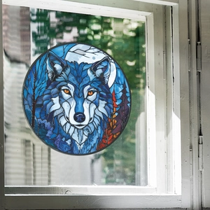Detail of round stained glass window film featuring a blue wolf, moon, and forest