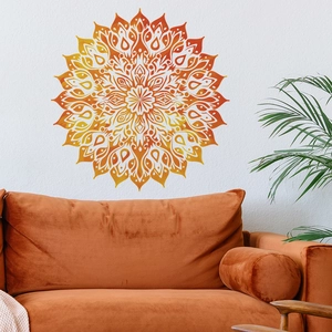 Detail of warm gradient mandala wall decal on white textured wall above orange velvet sofa
