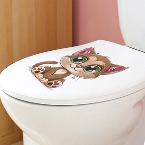 Detail view of a cute brown cartoon cat sticker applied to a white toilet lid