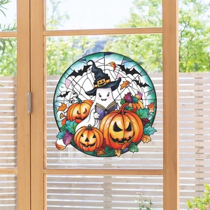 Close-up of Halloween window sticker with ghost reading a book and carved pumpkins