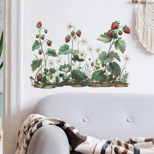 Detail of strawberry plant wall stickers with red berries and flowers on a white wall