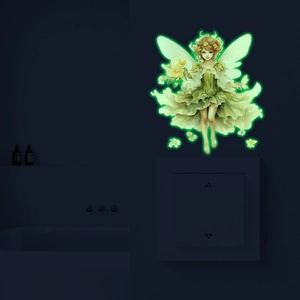 Luminous fairy wall sticker with green wings glowing on a light switch in a dark room