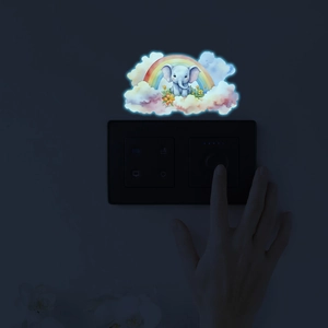 Luminous wall sticker showing a cartoon elephant on a rainbow glowing in the dark