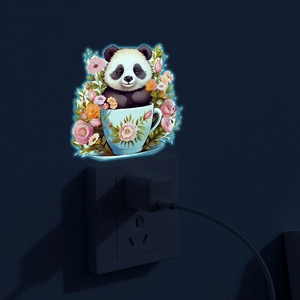 Luminous wall sticker featuring a cute panda in a floral teacup glowing on dark wall