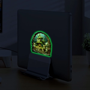 Close-up of glow-in-the-dark mouse hole sticker on a laptop with luminous details