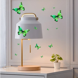 Detail view of various sizes of green glow-in-the-dark butterfly wall stickers for home decor