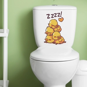 Close-up of cute cartoon sleeping ducks sticker applied on a white toilet tank