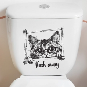 Detail of artistic black and white cat wall sticker with 'flush away' text on a toilet tank