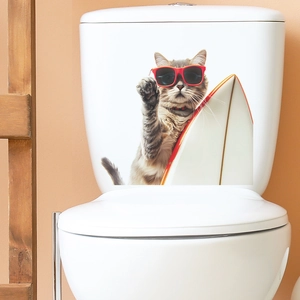 Detail of self-adhesive cat surfing wall sticker applied on a white toilet tank
