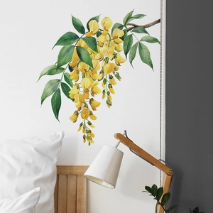 Detail view of yellow flower wall decals hanging above a cozy bedroom headboard
