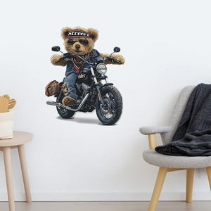 Detail view of motorcycle riding bear wall sticker on white wall above grey sofa