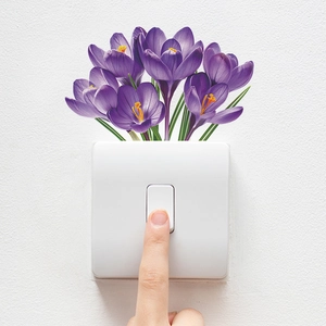Close-up of purple crocus flower wall sticker applied above a white light switch