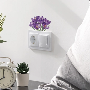 Close-up of purple crocus flower wall stickers applied above a home light switch