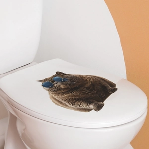 Detailed view of 3D cat wall sticker with blue sunglasses applied on white toilet lid