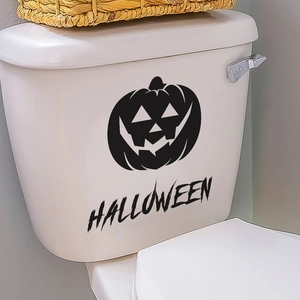 Nahaufnahme von Halloween-Kürbis-Aufklebern und HALLOWEEN-Schriftzug auf weißem WC-Kasten