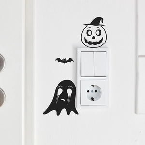 Halloween pumpkin face and ghost wall stickers decorating a white light switch panel