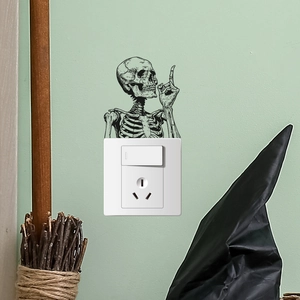 Detail of creative skeleton wall sticker pointing above a light switch for Halloween decor