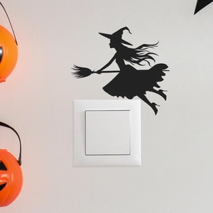 Halloween black silhouette wall sticker of a witch on a broom above a white light switch