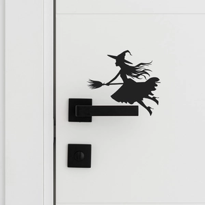Detailed view of black witch silhouette wall decal applied on a white door surface