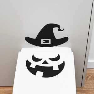 Detail of Halloween witch hat and pumpkin face stickers on a white toilet lid cover
