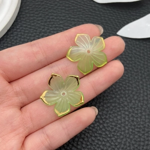 Detail von hellgrünen Acryl-Kirschblüten mit goldenem Rand und Loch für DIY-Schmuck