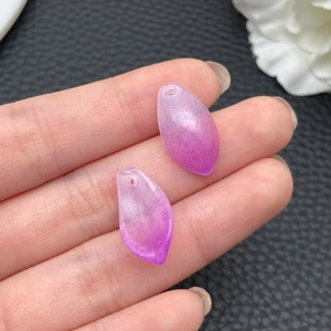 Close-up of translucent purple lotus leaf glass pendants for DIY jewelry making