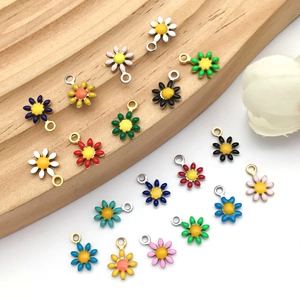 Macro detail of colorful enamel daisy flower pendants with gold and silver metal loops