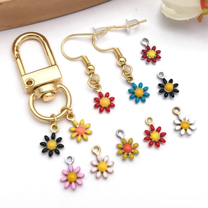 Close-up of assorted colorful enamel daisy charms and gold-plated lobster clasp findings