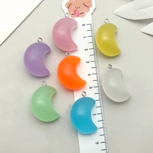 Detailed close-up of 2.5cm colorful resin crescent moon charms with metal jump rings