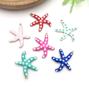 Detailed view of colorful starfish enamel charms with white polka dots and gold rings