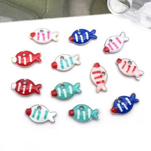 Detailopname van kleurrijke emaille visbedeltjes voor het maken van DIY-sieraden