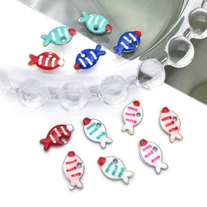 Kleurrijke vissenhangers met emaille voor DIY-kettingen op helder decoratief glas
