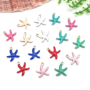 Vue macro de pendentifs étoile de mer en émail coloré pour bijoux DIY avec anneaux dorés