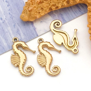 Detailed close-up of three golden seahorse charms for DIY jewelry with ocean starfish