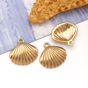 Detailed macro of golden shell pendants with textured finish and secure top rings