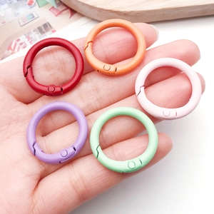 Primer plano de anillos de resorte coloridos de 24 mm en aleación para joyería artesanal