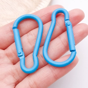 Detail view of two blue gourd-shaped aluminum carabiners with matte spray finish
