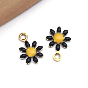 Detailansicht von zwei schwarzen Emaille-Gänseblümchen-Anhängern für DIY-Schmuckherstellung
