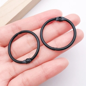 Close-up of 30mm matte black metal binder rings with hinged opening for DIY crafts