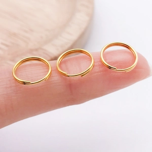 Detaillierte Makroansicht von drei kleinen goldenen Spaltringen für DIY-Schmuck und Anhänger