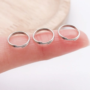 Makroansicht von silbernen Spaltringen auf Fingerspitzen für DIY-Schmuck und Anhänger