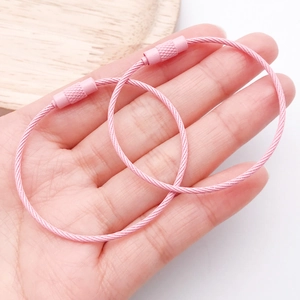 Vista macro dei portachiavi in acciaio inossidabile rosa con connettori a vite zigrinata