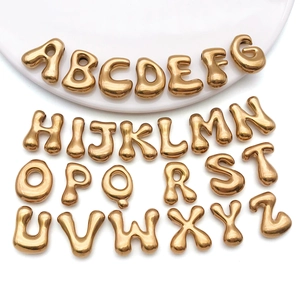 Détail de perles lettres dorées au design bulle pour la création de bijoux DIY personnalisés
