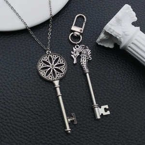 Détail du pendentif clé en argent vieilli et porte-clés hippocampe sur cuir noir