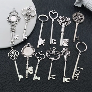 Assortiment de breloques clés vintage en alliage argenté pour bijoux DIY sur noir
