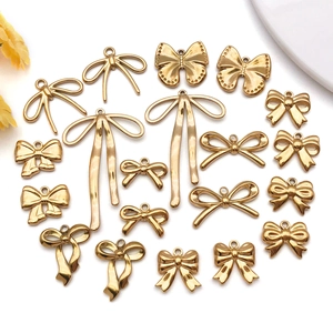Vista macro de varios dijes de lazo de oro de 18K para hacer joyas de bricolaje