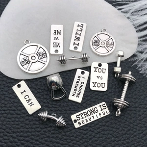 Detailed view of antique silver gym charms including kettlebell and dumbbell pendants