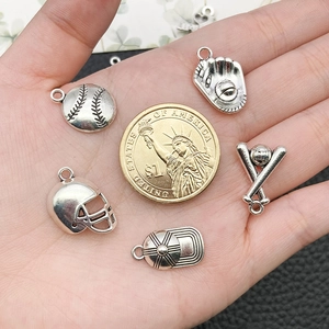 Macro view of five antique silver sports charms including baseball and helmet with coin