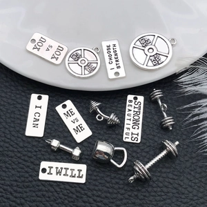 Detailed view of antique silver gym charms with engraved fitness motivation slogans