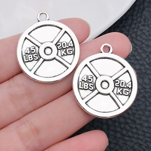 Close-up of vintage silver weight plate charms with 45 LBS and 20.4 KG engravings